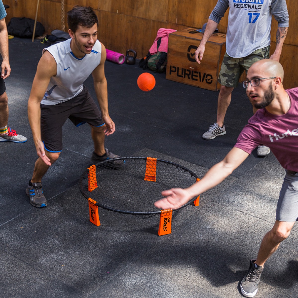 Dos adultos jugando Strike 360 en un gimnasio
