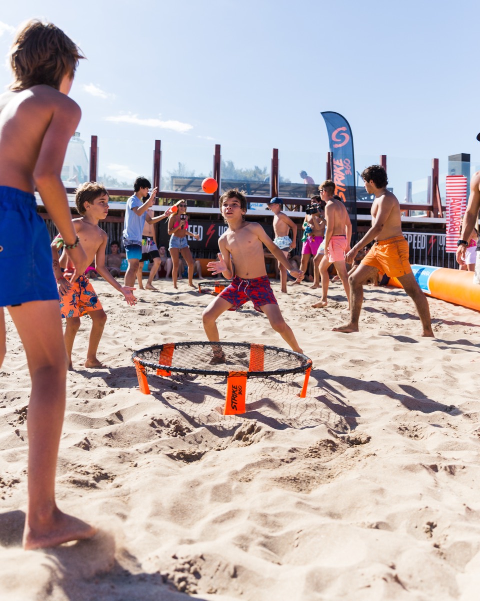 Chicos jugando Strike 360 en la playa
